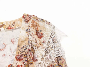 Detail of bohemian floral dress showing shoulder lace stitching and vintage print