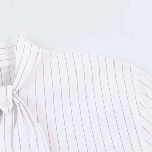 Detail of white striped shirt showing the tie-neck bow and vertical brown stripes