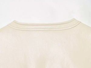 Detail shot of a matte cream leather vest showing the round neckline and double stitching