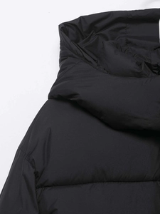 Detailed close-up showing durable stitching and matte texture on a black hooded puffer jacket