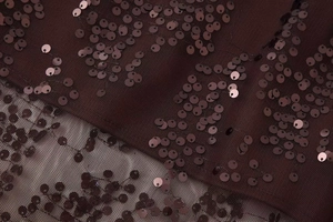 Detail of burgundy mesh fabric with vertical rows of shiny sequins for a high-waist skirt