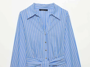 Detail of blue striped shirt dress showing golden buttons and belted waistline