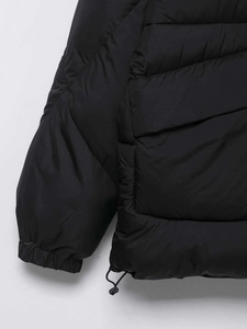 Macro detail of black quilted puffer jacket with adjustable drawstring hem and elastic cuffs