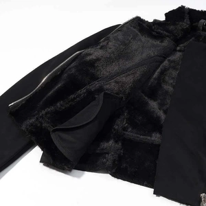 Detail shot of winter jacket featuring thick black faux fur lining and silver metal zipper
