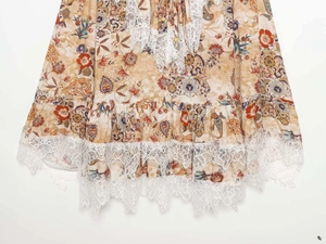 Close-up of floral dress hem with delicate white eyelash lace trim and vintage flower pattern