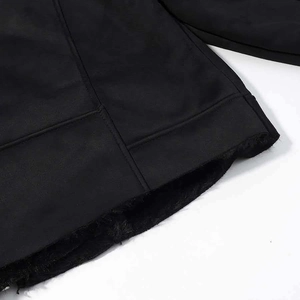 Detailed close-up of faux suede jacket hem featuring thick black faux fur lining textures