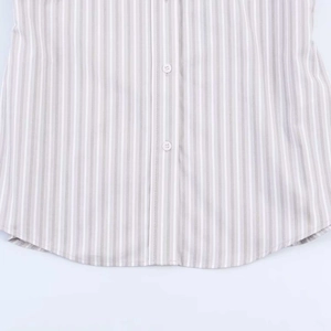 Detail of vertical striped shirt showing button placket and rounded hemline finish