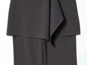 Detail view of dark grey trousers with asymmetric layered design and smooth stitching