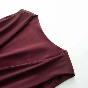 Macro detail of wine red jumpsuit shoulder with seamless stitching and silky fabric texture