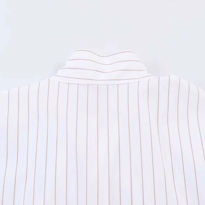 Detailed close-up of white and brown striped shirt with high-quality woven cotton texture