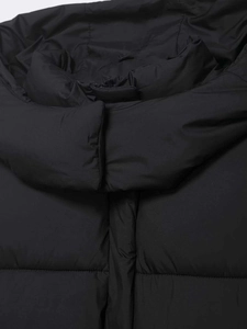 Detailed close-up of the high collar and zipper on this black quilted puffer jacket