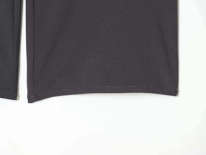 Detailed macro view of charcoal grey trousers hem featuring high-quality flat stitching