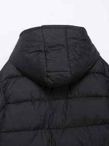 Detail view of the quilted stitching and hooded structure on a black winter padded coat