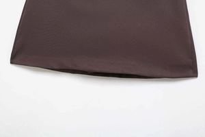 Detail of high-waist mini skirt hem featuring dark brown fabric and fine stitching