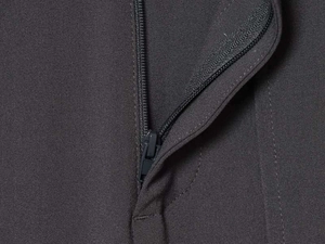 Macro shot of high-quality zipper detail and woven texture on grey trousers