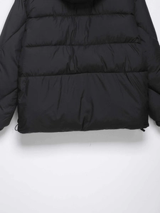 Detailed view of black quilted jacket with adjustable drawstring hem and neat stitching