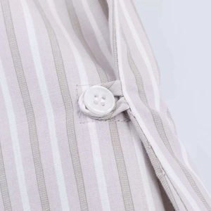 Close-up of vertical striped shirt fabric with white button detail and fine texture