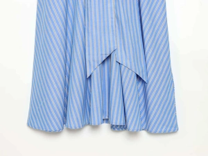 Detailed view of blue striped shirt dress featuring asymmetric hem and cotton texture