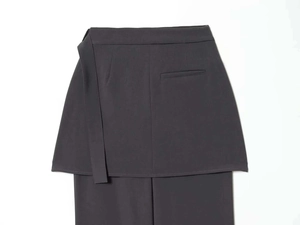Detailed view of dark grey layered skirt-trousers with side ties and fine tailoring