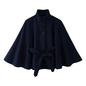 Detail of navy blue cape coat with stand collar and waist belt on white background