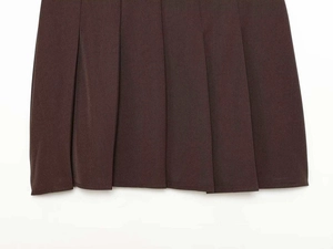 Close-up of deep brown pleated skirt showing high-quality fabric texture and neat folds