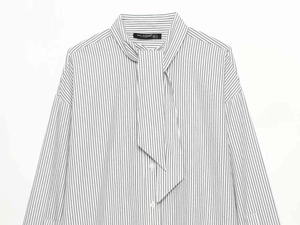 Detailed view of striped long sleeve shirt neck bow tie and Zeal Woman brand label