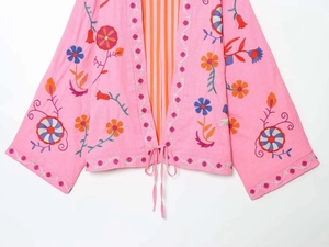 Detailed embroidery on a pink kaftan jacket with a striped interior lining