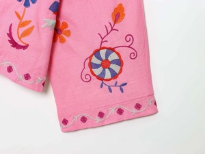 Close-up of pink cotton kaftan sleeve featuring bohemian floral embroidery and vine borders