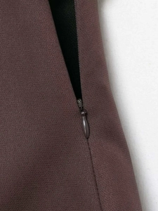 Close-up of invisible zipper and textured burgundy high-waisted mini skirt fabric