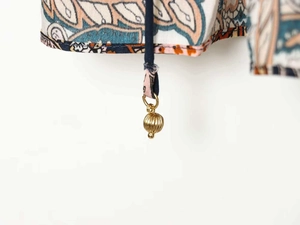 Détail de mousseline à imprimé paisley ethnique avec lien marine et perle dorée