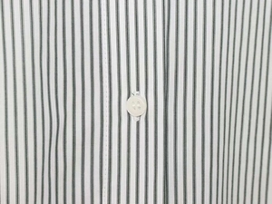 Macro view of vertical striped fabric texture and white button detail on summer shirt