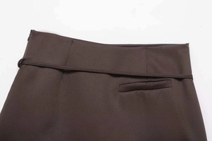 Close-up of high-waist dark brown mini skirt with thin matching belt and welt pocket