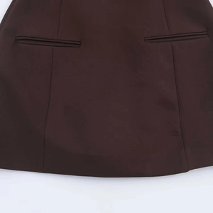 Detail of dark brown dress with pleated texture and refined back welt pockets