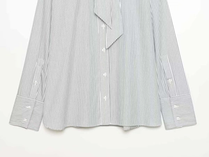 Detail view of striped long sleeve shirt with sharp collar and buttoned cuffs