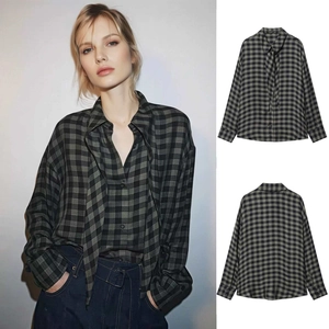 Detail of grey plaid shirt featuring a retro tie-neck design and soft cotton fabric