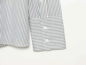 Detailed close-up of striped long sleeve shirt cuffs with white buttons and precise stitching