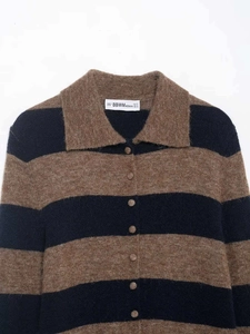 Détail du col d'un cardigan rayé en maille avec boutons et texture pelucheuse
