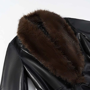 Gros plan sur une veste en cuir noir avec un col en fausse fourrure marron foncé épais