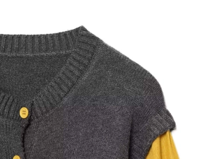 Detailed close-up of dark grey striped knit cardigan with contrast yellow buttons and collar