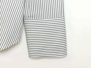 Detail of white and black vertical striped shirt featuring horizontal stripe cuffs