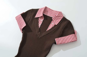 Detail of knit shirt collar with red gingham patchwork and white buttons