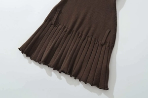 Detail view of dark brown ribbed knit pleated hem with lettuce edge finish