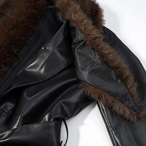 Gros plan du col en fausse fourrure marron et de la texture du cuir noir sur le manteau