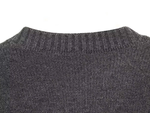 Detailed close-up of dark grey striped knit sweater showing ribbed neckline texture