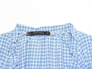 Detailed view of blue and white gingham shirt collar with size M brand label
