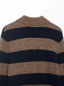 Détail d'un pull en maille rayé marron et bleu marine montrant la texture de laine douce