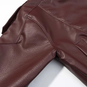Detail view of burgundy leather bomber jacket showing premium stitching and pebble texture