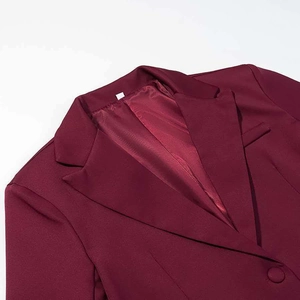 Détail du revers d'un blazer bordeaux avec doublure satinée et tissu texturé de qualité