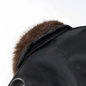 Détail d'un manteau en cuir noir avec col en fausse fourrure marron et coutures précises
