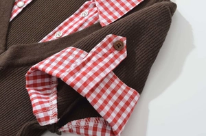 Close-up of brown ribbed knit fabric with red gingham patchwork and button details